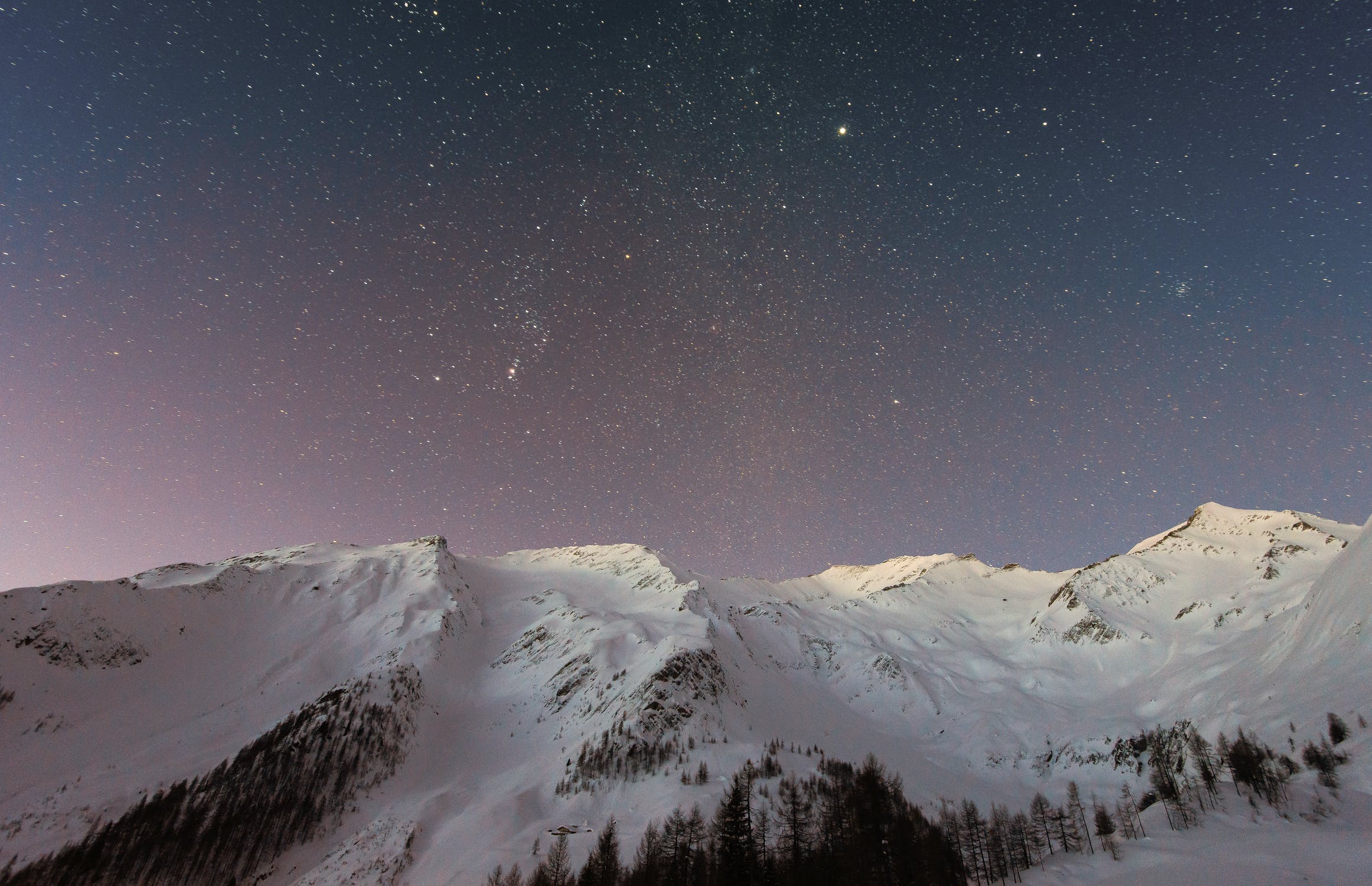 Snow-covered ridges beneath a starry sky